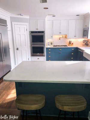 Blue and white cabinets done right with white quartz and white subway tile.
